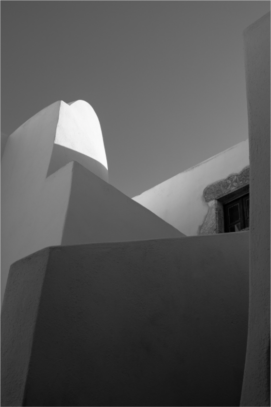 Black and white fine art photograph of traditional Cycladic architecture and geometric shadows in Emborio, Santorini