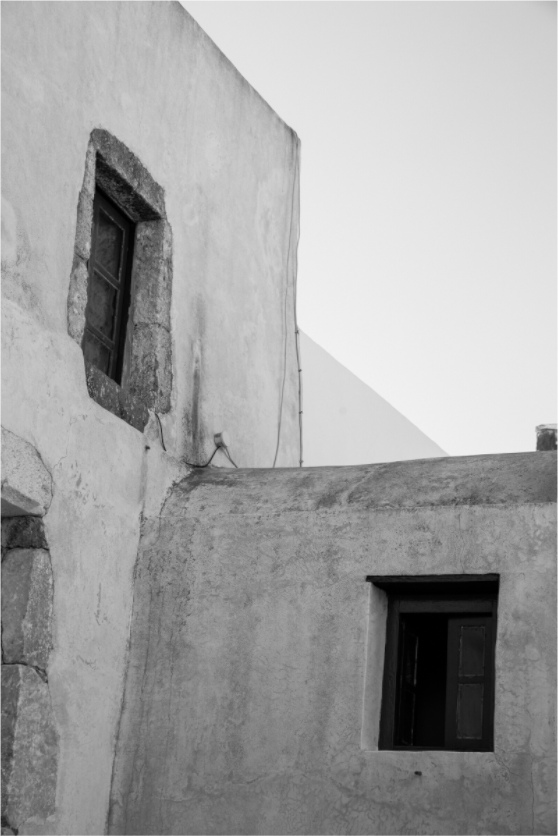 Black and white photograph of weathered Cycladic walls and windows in Emborio, Santorini.