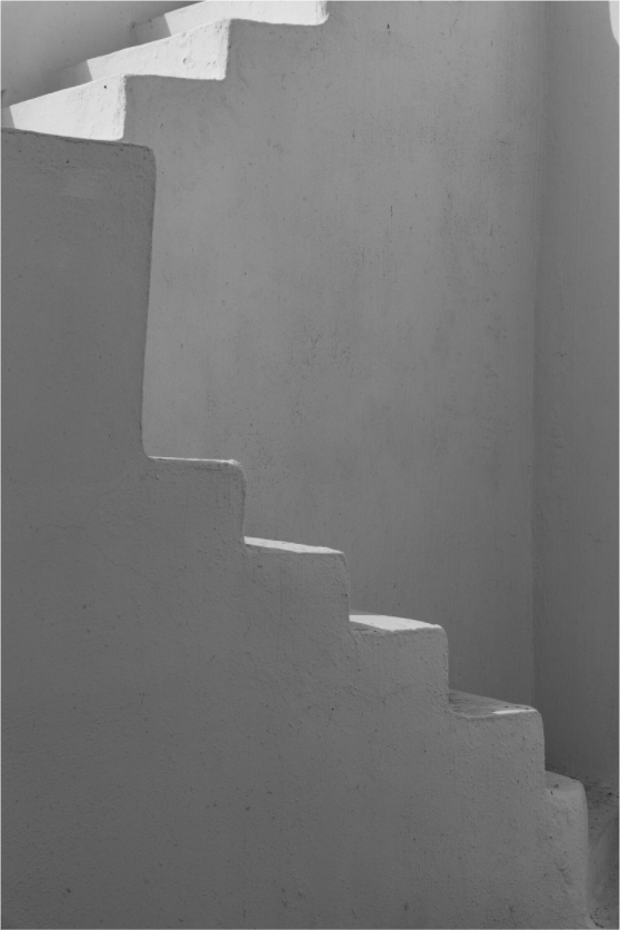 Black and white abstract study of whitewashed Cycladic steps and shadows in Oia, Santorini