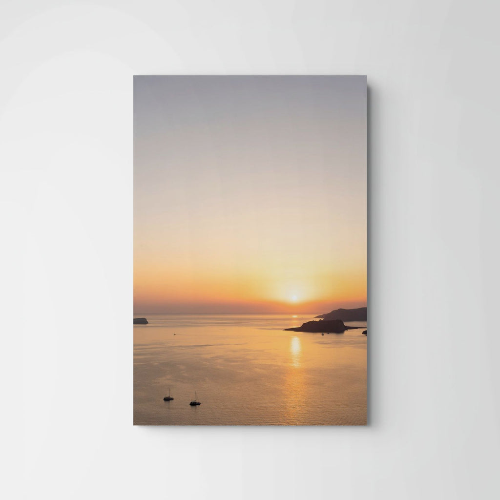 Minimalist Santorini sunset over the Aegean Sea with golden light reflecting across calm water.