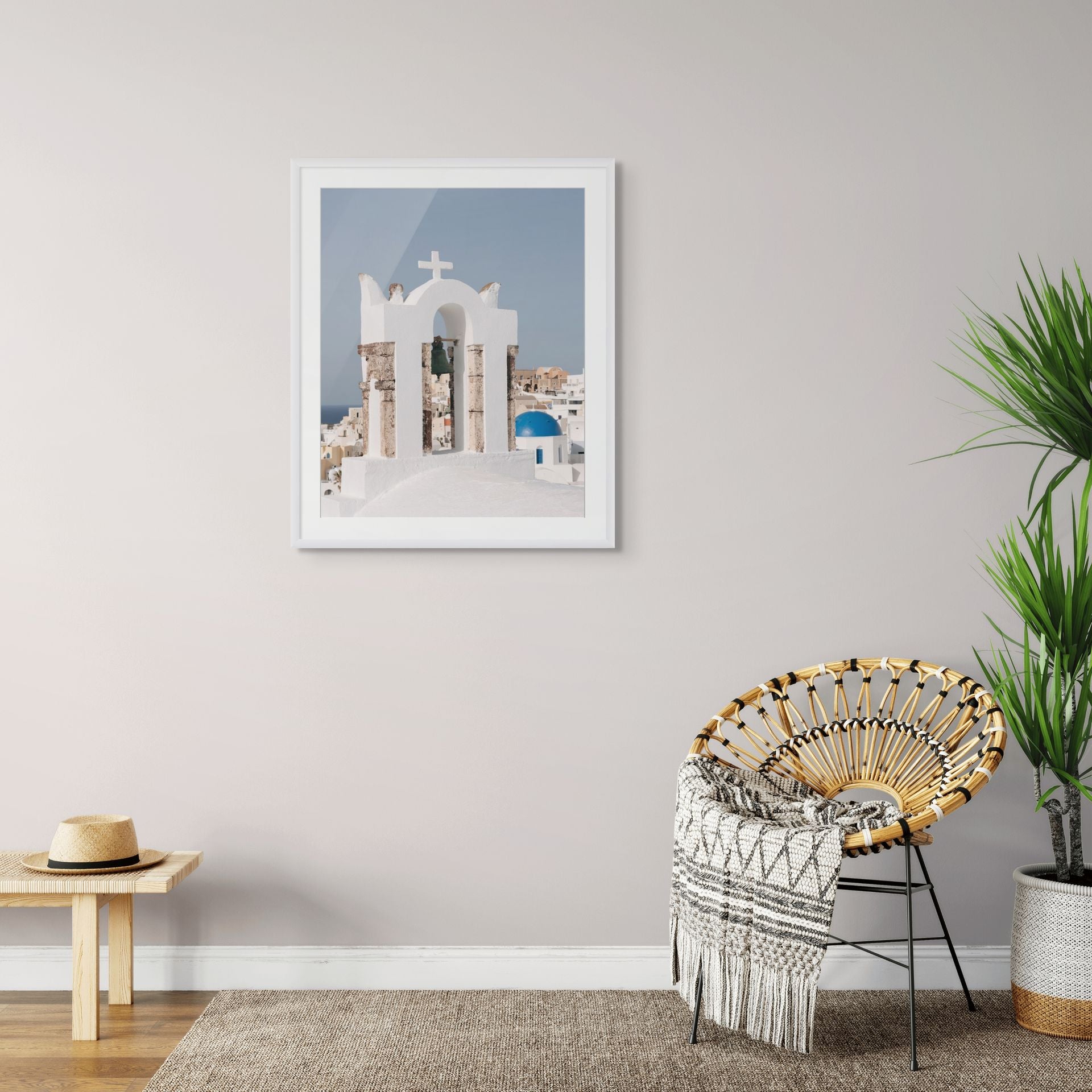 Traditional white bell tower overlooking Oia with a blue-domed church and whitewashed Cycladic architecture on Santorini, Greece.